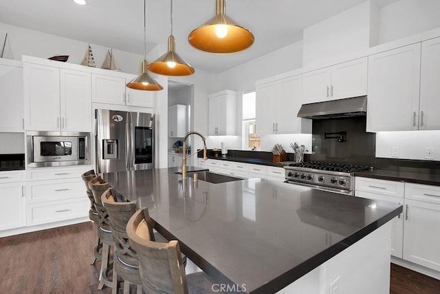 kitchen featuring hanging light fixtures, a center island with sink, stainless steel appliances, and sink