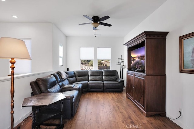 living room with ceiling fan and dark wood-type flooring