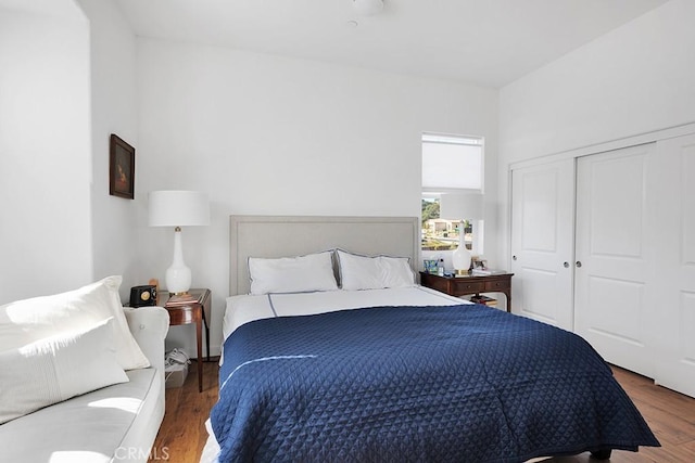 bedroom with dark hardwood / wood-style floors and a closet