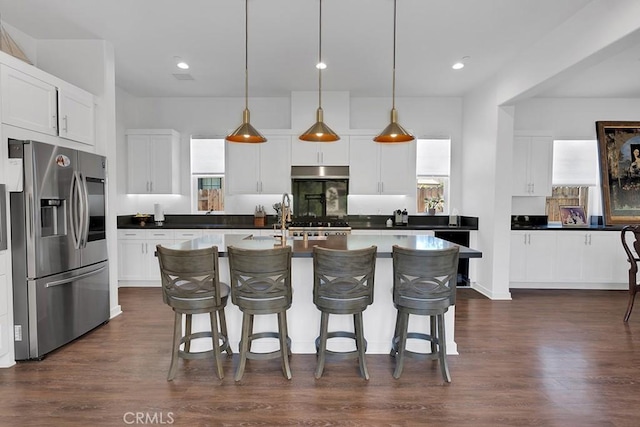 kitchen featuring dark wood-type flooring, white cabinets, pendant lighting, and stainless steel refrigerator with ice dispenser