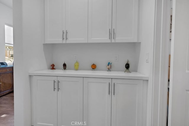 bar featuring white cabinets and hardwood / wood-style flooring