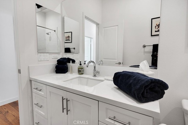 bathroom with a shower, hardwood / wood-style floors, vanity, and toilet