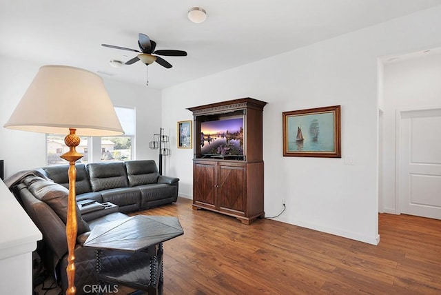 living room with ceiling fan and dark wood-type flooring