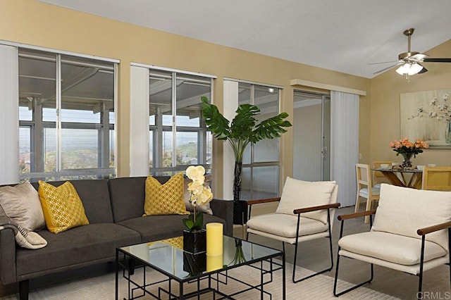 living room featuring vaulted ceiling, ceiling fan, and a healthy amount of sunlight