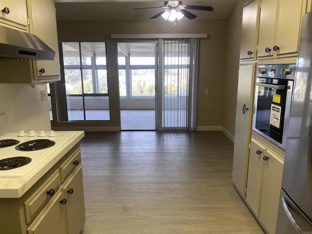 kitchen featuring white electric cooktop, wall oven, cream cabinetry, and light wood-type flooring