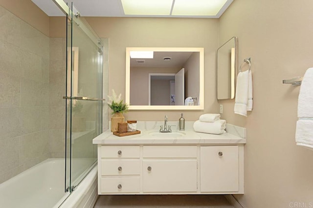 bathroom featuring bath / shower combo with glass door and vanity