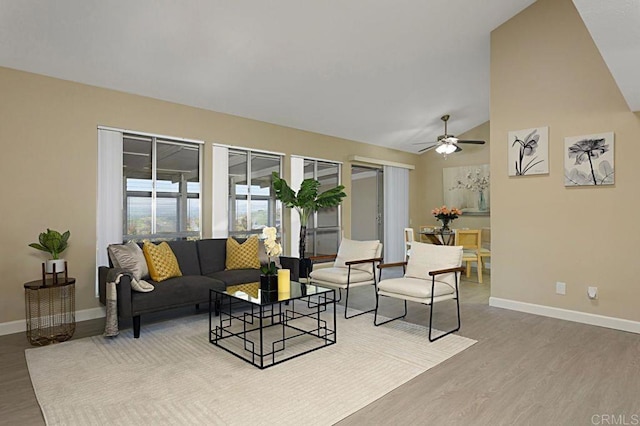 living room with ceiling fan, lofted ceiling, and light hardwood / wood-style flooring