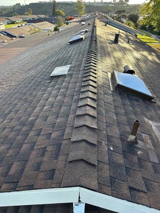 exterior details featuring roof with shingles