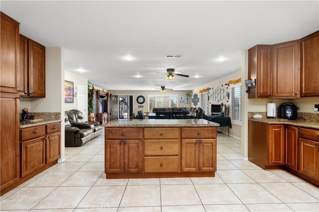 kitchen with light stone countertops, ceiling fan, and light tile patterned floors