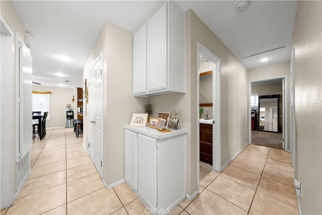 corridor with sink, light tile patterned flooring, and washer / clothes dryer