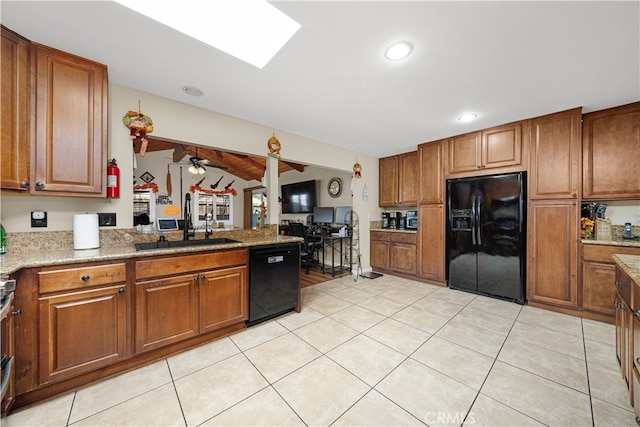 kitchen featuring lofted ceiling, sink, black appliances, light tile patterned floors, and ceiling fan