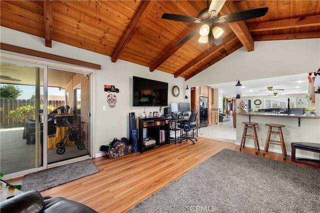 living room with ceiling fan, lofted ceiling with beams, wooden ceiling, and light hardwood / wood-style flooring