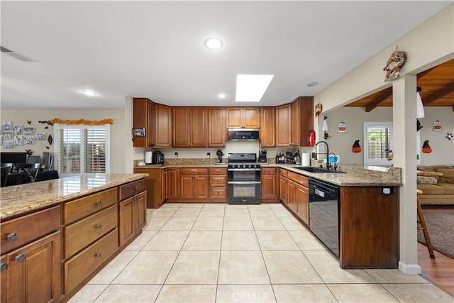 kitchen with a healthy amount of sunlight, black appliances, sink, and exhaust hood