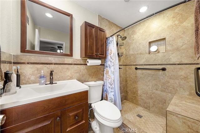 bathroom featuring vanity, toilet, walk in shower, and tile walls