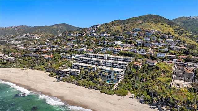 birds eye view of property featuring a water and mountain view and a view of the beach