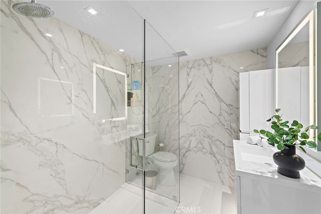 bathroom with toilet, vanity, and tiled shower