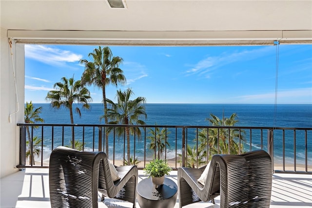 balcony featuring a water view and a beach view