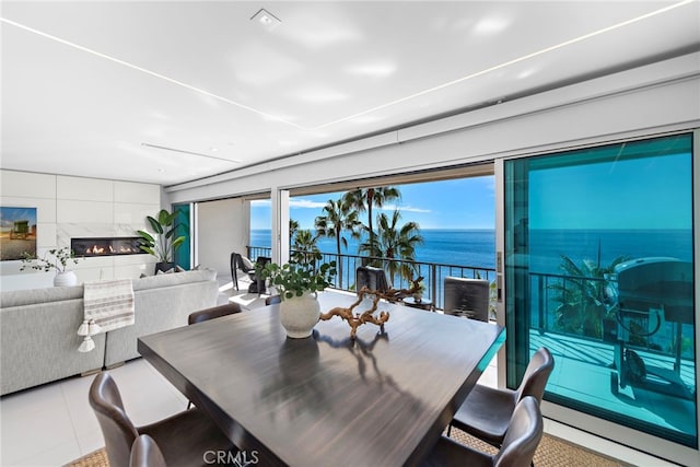 tiled dining area featuring a water view and a fireplace