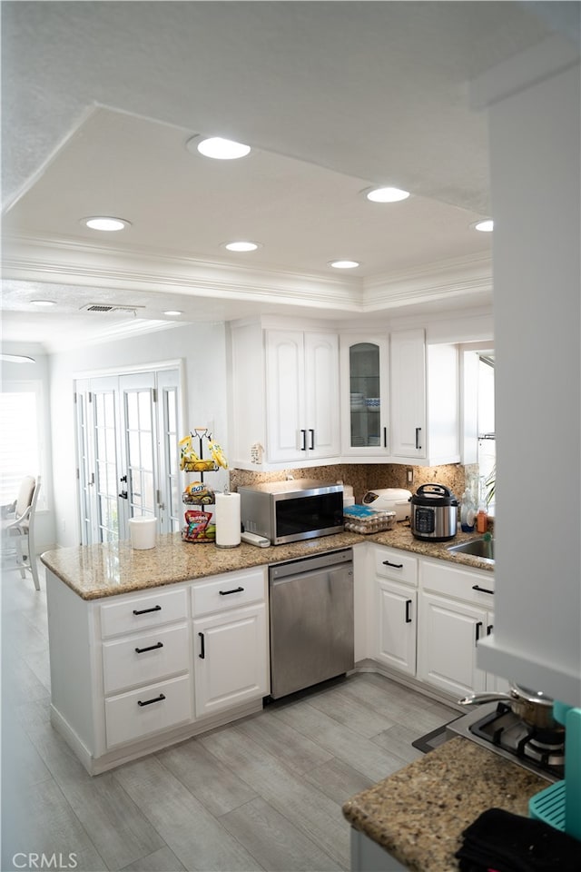 kitchen featuring appliances with stainless steel finishes, white cabinetry, and light hardwood / wood-style floors