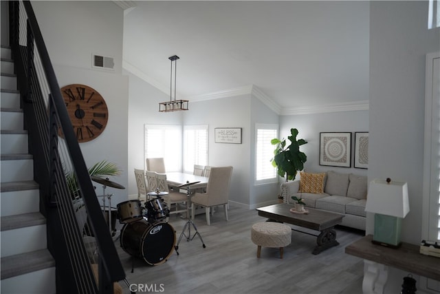 living room featuring ornamental molding, lofted ceiling, and light hardwood / wood-style floors