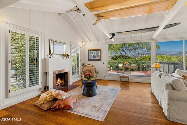 sunroom / solarium featuring ceiling fan and vaulted ceiling with beams