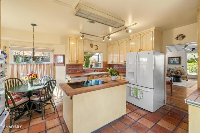 kitchen featuring a chandelier, pendant lighting, light brown cabinetry, black electric cooktop, and white fridge with ice dispenser