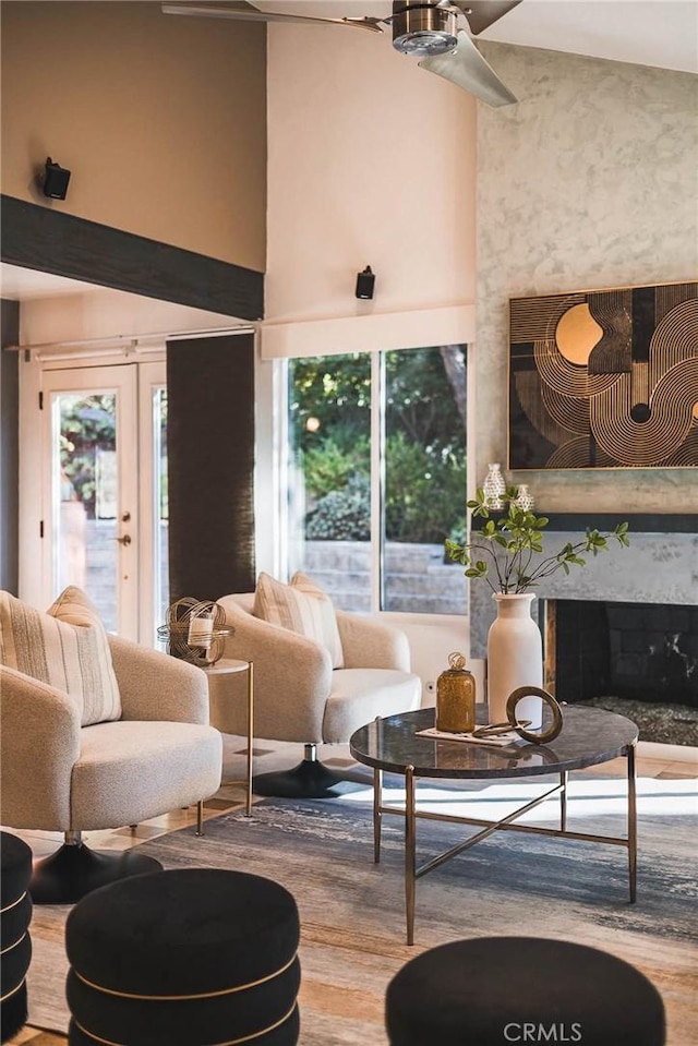 interior space with hardwood / wood-style floors, a towering ceiling, a fireplace, and french doors