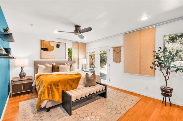 bedroom with access to exterior, french doors, light wood-type flooring, and ceiling fan