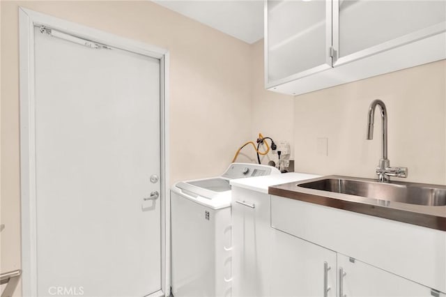 laundry area with washer and clothes dryer, sink, and cabinets