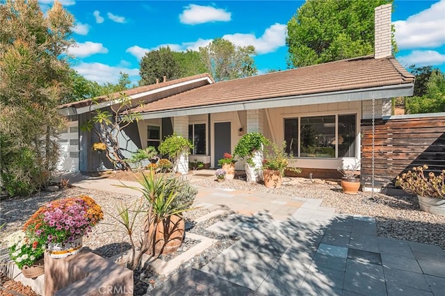 back of house with covered porch and a garage