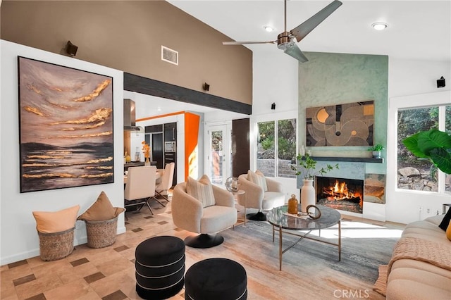 living room with ceiling fan, a fireplace, and high vaulted ceiling