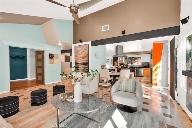 living room featuring ceiling fan and high vaulted ceiling