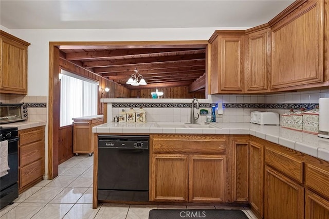 kitchen featuring decorative backsplash, tile countertops, an inviting chandelier, and black appliances