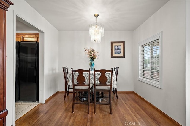 dining area featuring hardwood / wood-style floors and a notable chandelier