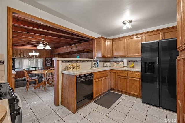 kitchen featuring tasteful backsplash, black appliances, tile countertops, a notable chandelier, and hanging light fixtures