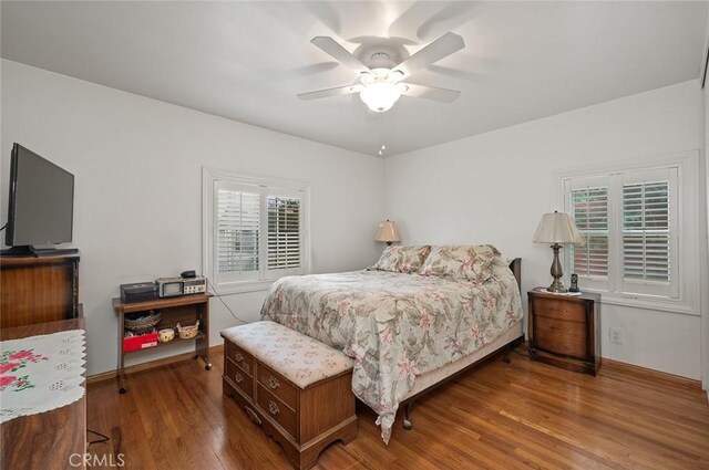 bedroom featuring multiple windows, ceiling fan, and wood-type flooring