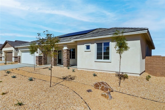 view of front of property with solar panels and a garage