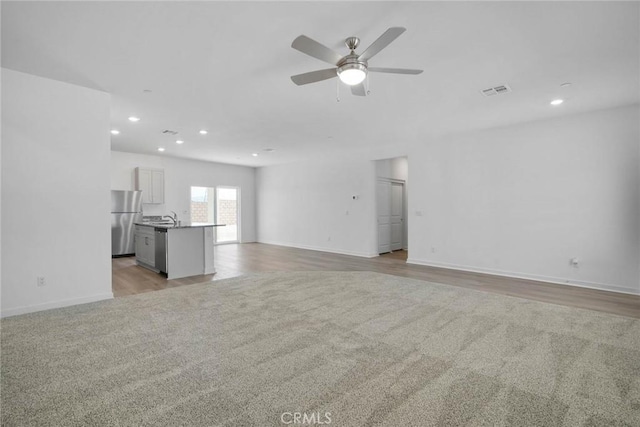 unfurnished living room with ceiling fan and light hardwood / wood-style floors