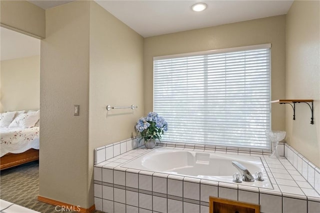 bathroom featuring tiled bath and a healthy amount of sunlight