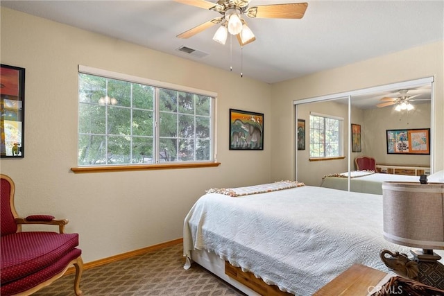 carpeted bedroom featuring ceiling fan, a closet, and multiple windows