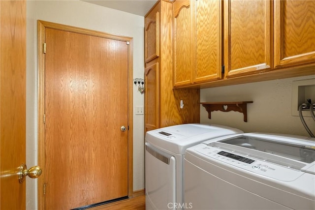 clothes washing area with cabinets and washer and clothes dryer