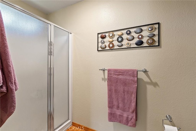 bathroom with hardwood / wood-style flooring and walk in shower