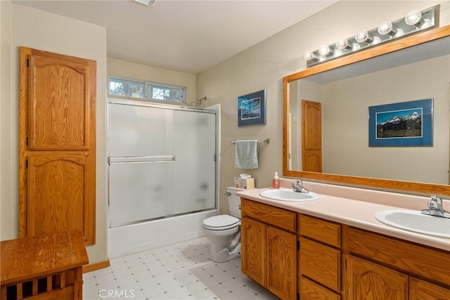 full bathroom featuring toilet, vanity, and combined bath / shower with glass door