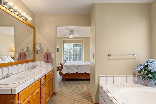 bathroom featuring vanity, ceiling fan, and a tub