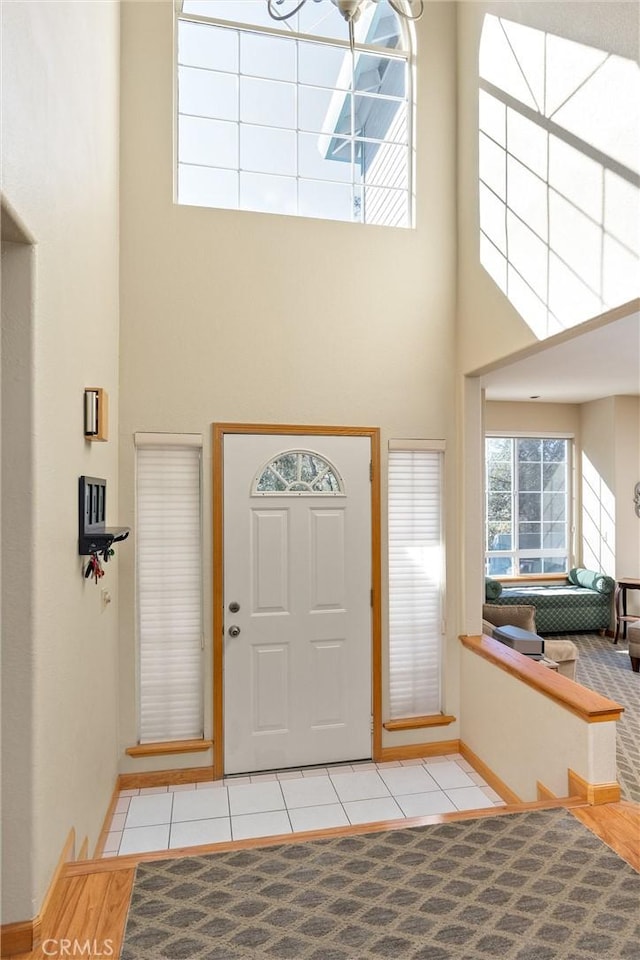 tiled foyer entrance featuring a towering ceiling