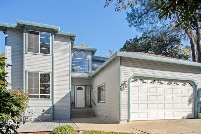 traditional-style house featuring a garage and concrete driveway