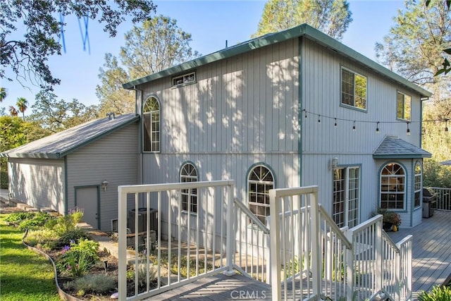 rear view of house featuring a wooden deck