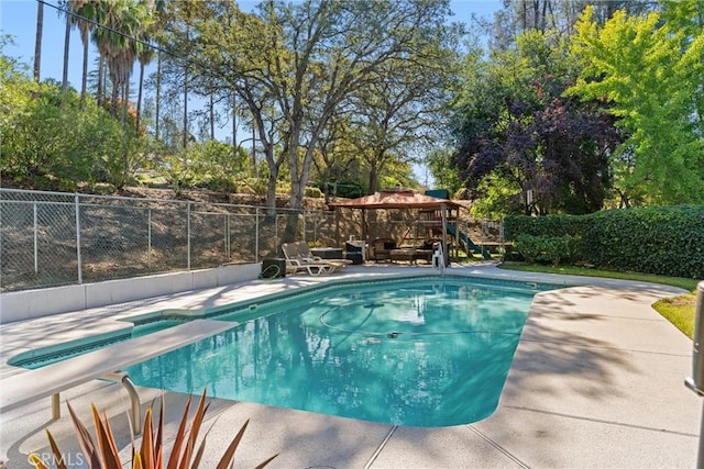 view of pool with a patio and a diving board