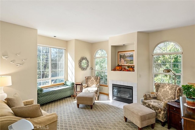 sitting room featuring a fireplace, light colored carpet, and a healthy amount of sunlight