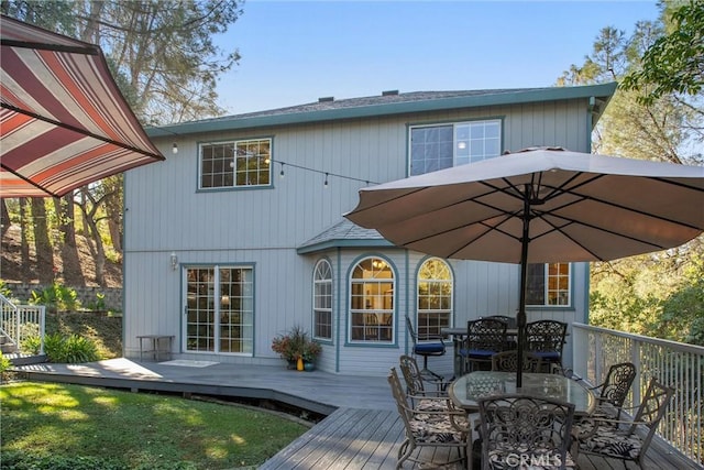 back of property featuring a deck and outdoor dining space